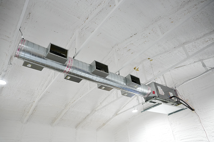 Interior view of a Navien NAS series air handler showing the ductwork and ceiling-mount installation in a converted barn.