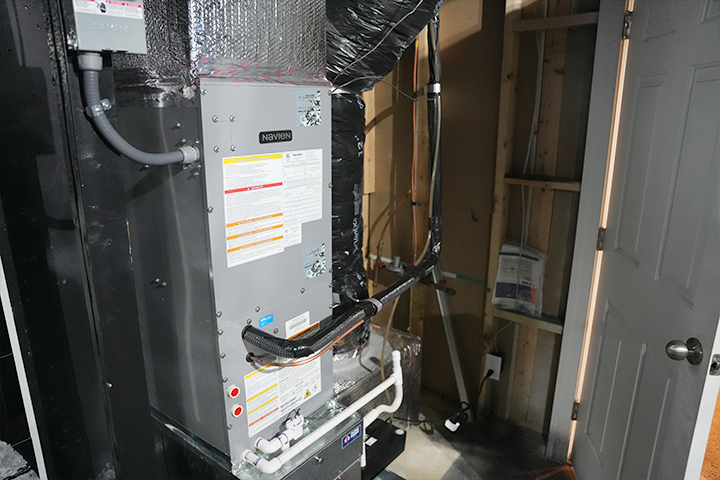 Compact Navien NAS series residential air handler installed with ductwork in a basement retrofit.