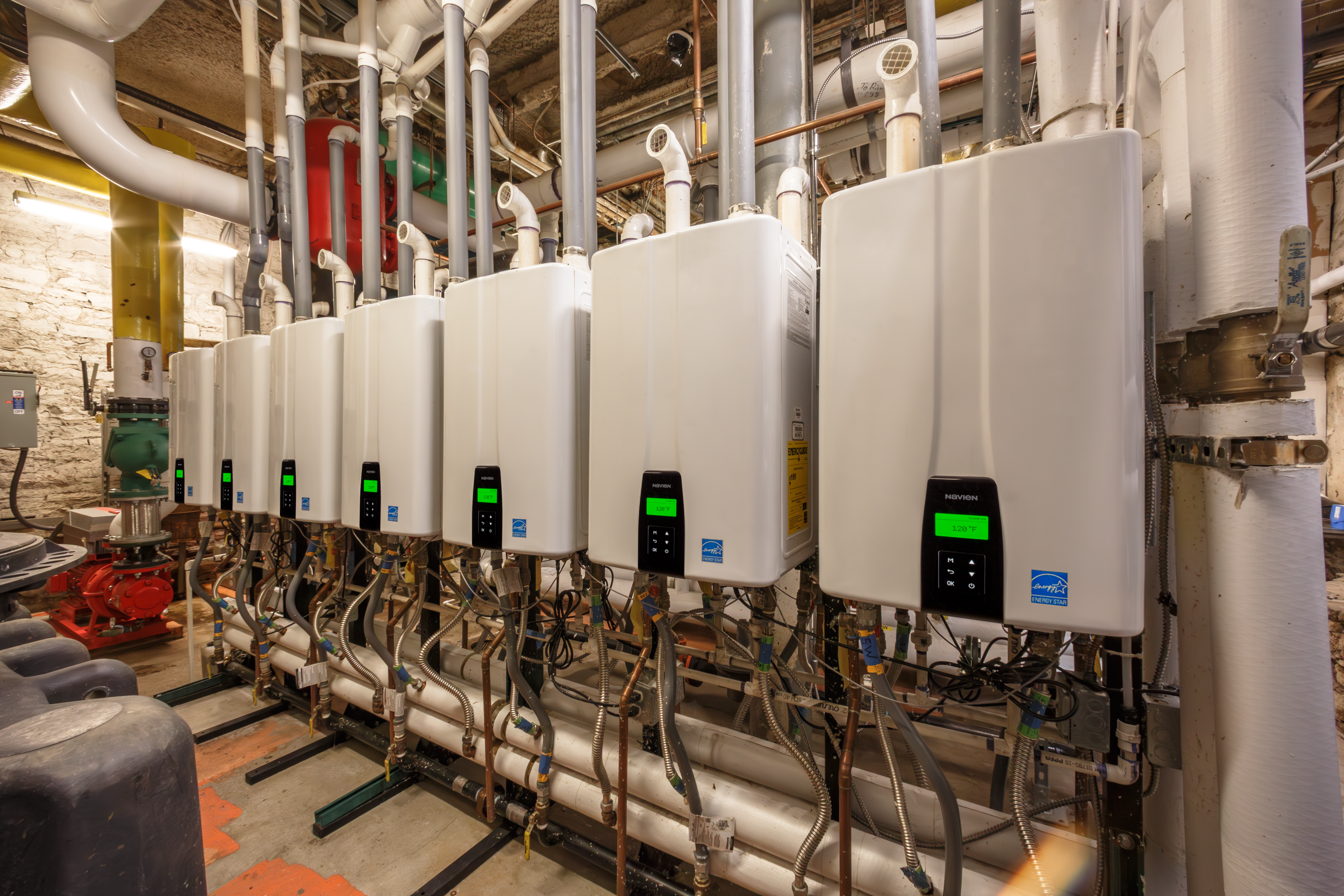 wall-mounted Navien NPE-240A2 tankless water heaters installed in the basement boiler room of The Oxford Hotel