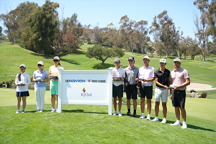 Junior golf championship winners posing in front of the Navien sponsorship banner.