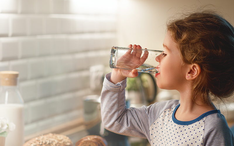 Girl drinking water from a glass cup